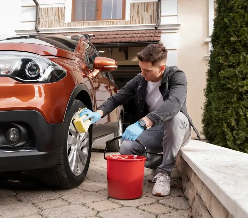 Lavage auto à domicile Guiry-en-Vexin : professionnel intervenant sur un véhicule